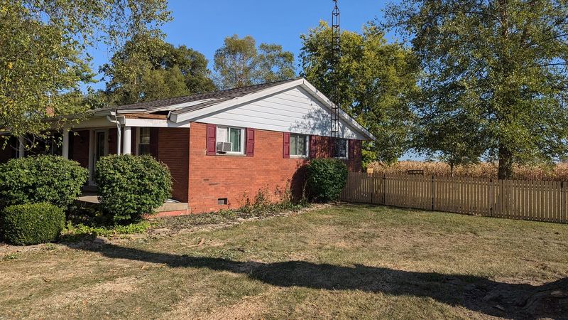 The same brick house with the tree gone and the lawn cleared.